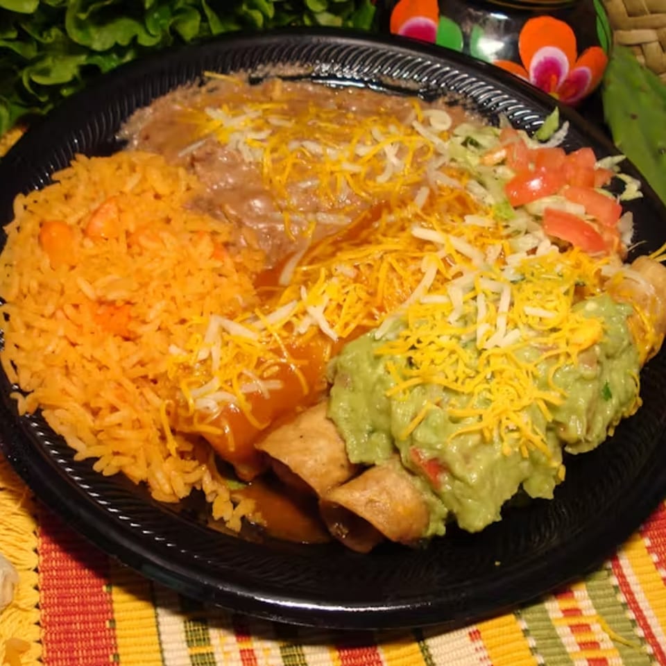 A Los Portales Taco Shop combo plate with rice, beans, enchiladas, taquitos, guacamole, and salad.