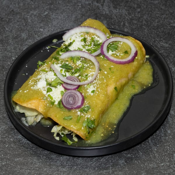 A Los Portales enchilada covered in green sauce, cheese, cilantro, and red onion slices.
