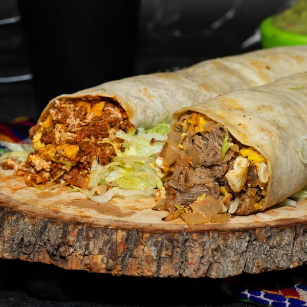 Two large, open Los Portales burritos with various fillings, including meat, cheese, and lettuce, on a wooden board.