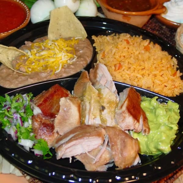 Los Portales Taco Shop's carnitas plate with rice, refried beans, guacamole, and pico de gallo.